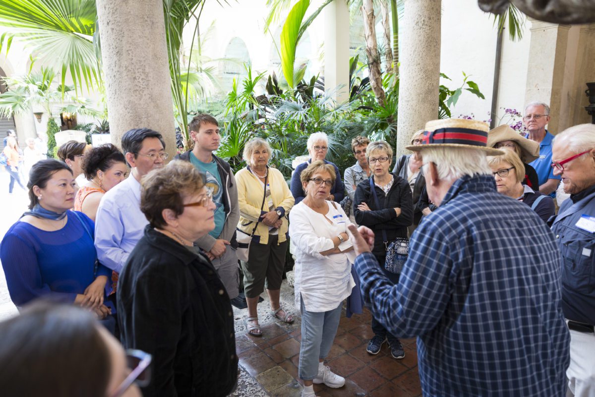 Museum visitors gather together to listen to a tour given by a museum guide