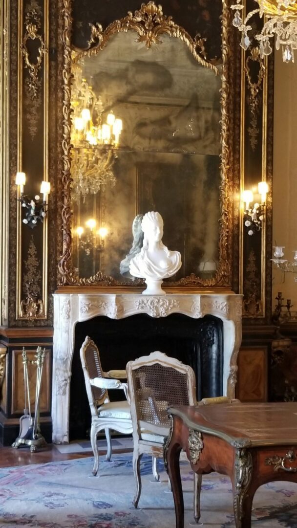 Antique mirror and bust on a fireplace in a living room