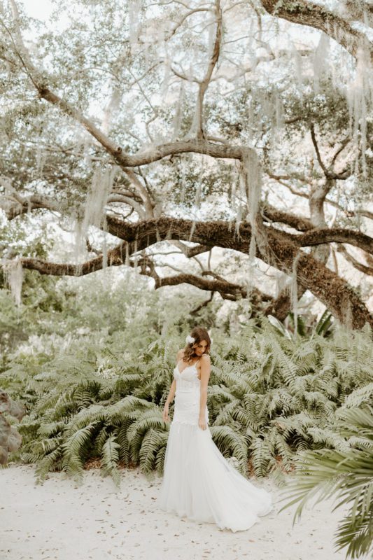 Bride wearing a white dress and standing in a garden