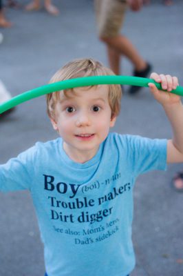 Young boy stops hula hooping to have his picture taken.