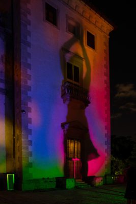 Visitors make shadows on the side of the Main House with projected light. Spectral Vizcaya, 2021