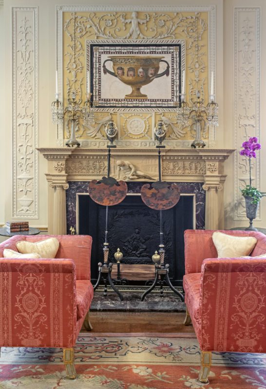 The fireplace located in Vizcaya's library feautring two red loveseats on either side
