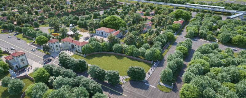 An arial view of Vizcaya Village, showing the East Gate Lodge, the West Gate Lodge and the Garage and Mechanic's Shop in the foreground. Trees abound throughout, with the Superintendent's House and Farm Quad in the background. The Vizcaya Station Metrorail station shows in the extreme background. 32 road shows to the North and South Miami Avenue shows to the East of Vizcaya Village.