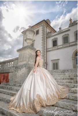Beautiful girl in a cream colored princess-style dress posing for her quince photos on the stairs of the East Terrace at Vizcaya. Photo by Ineslynn Photography