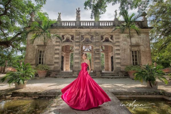 Lovely young lady in a fuscia dress poses for quince photos on the Garden Mound at Vizcaya. Photo by Ineslynn Photography