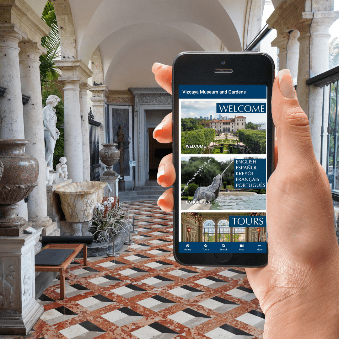 Visitor holding a smartphone that displays the Vizcaya Museum and Gardens app, which includes the audio tour and other digital experiences.
