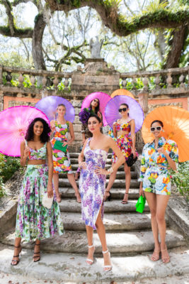 Women dressed in garden-themed dresses in front of Vizcaya's Garden Mound