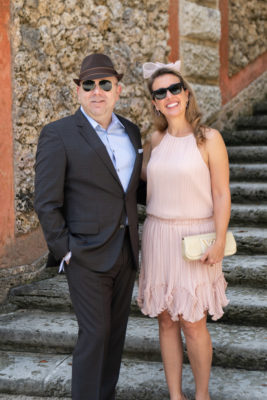 A man in a suit poses with a woman in a pink dress.