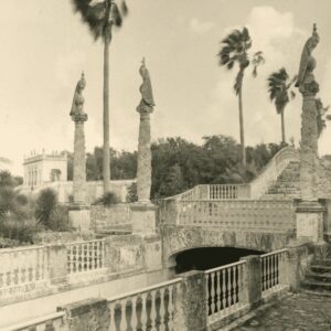 A black and white photo of a bridge and statues.