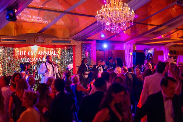 A group of people dancing at the Vizcaya Ball in a large room.