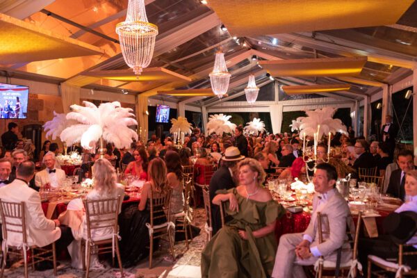 A group of people sitting at tables in a Vizcaya Ball room.