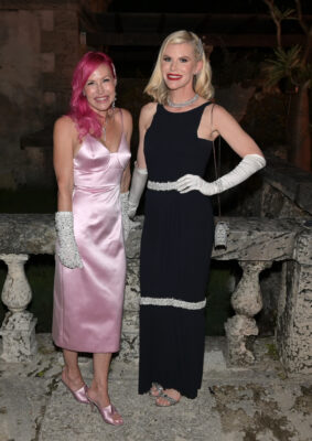 Two women in pink dresses standing next to each other at the Vizcaya Ball.