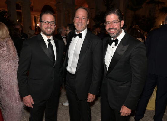 Three men in tuxedos standing next to each other at the Vizcaya Ball.