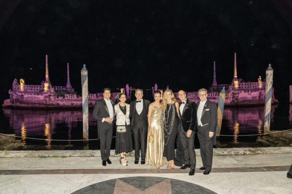 A group of people posing in front of a building at night during the Vizcaya Ball.