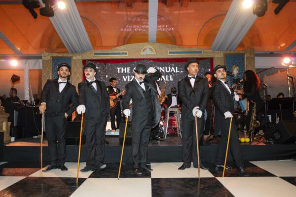 A group of men in black tuxedos standing on a checkered floor at the Vizcaya Ball.