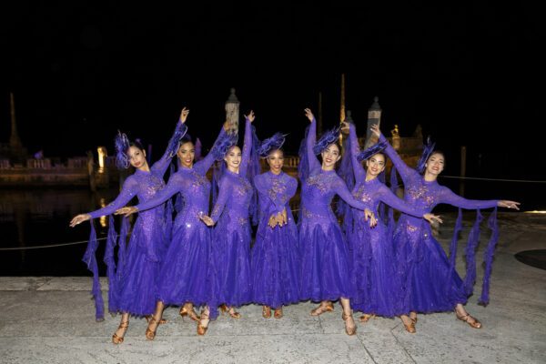 A group of dancers in purple dresses posing for a photo at the Vizcaya Ball.