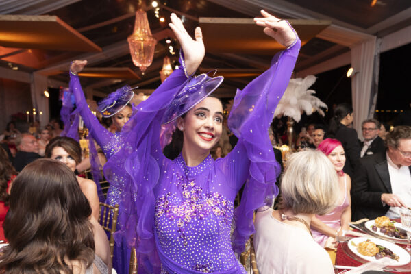 A group of women in purple dresses dancing at the Vizcaya Ball.