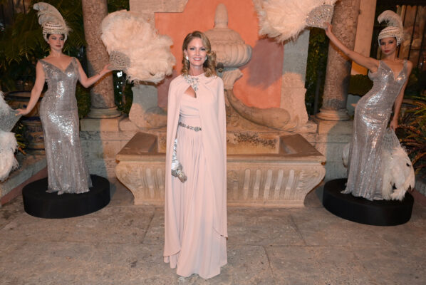 A woman in a dress standing in front of two statues at the Vizcaya Ball.