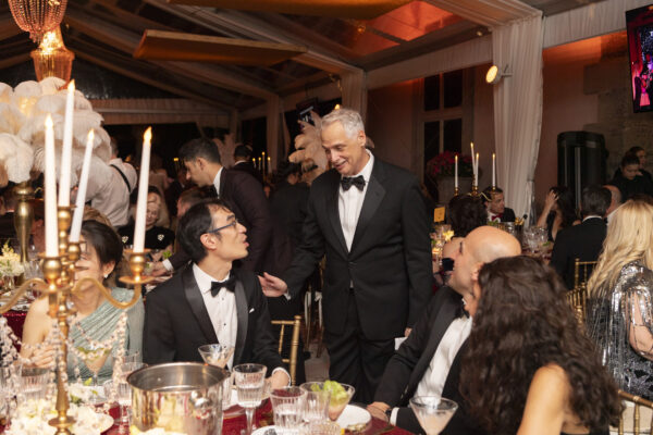A glamorous Vizcaya Ball gathering with attendees dressed in elegant tuxedos.