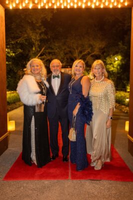 A group of people standing on a red carpet at the Vizcaya Ball.