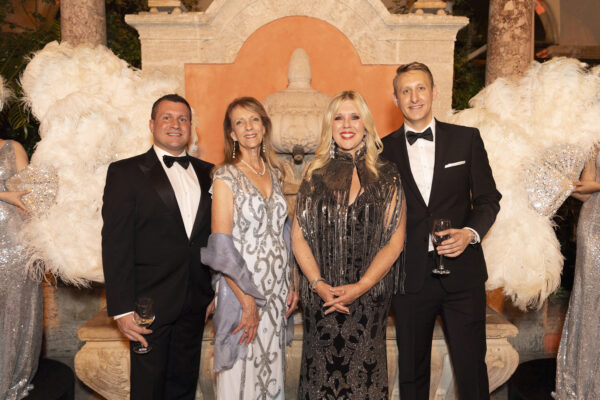 A group of people posing for a photo at the Vizcaya Ball in formal attire.