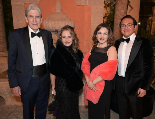 Four people in tuxedos posing for a photo at the Vizcaya Ball.