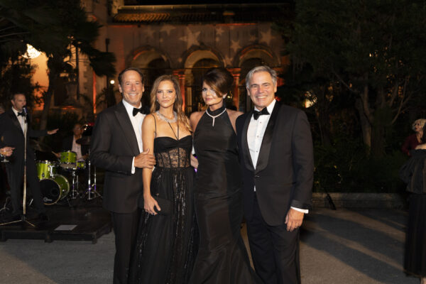 Four people in black tuxedos posing for a Vizcaya Ball photo.