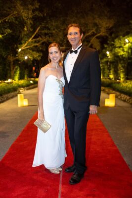 A man and woman standing on a red carpet at the Vizcaya Ball.