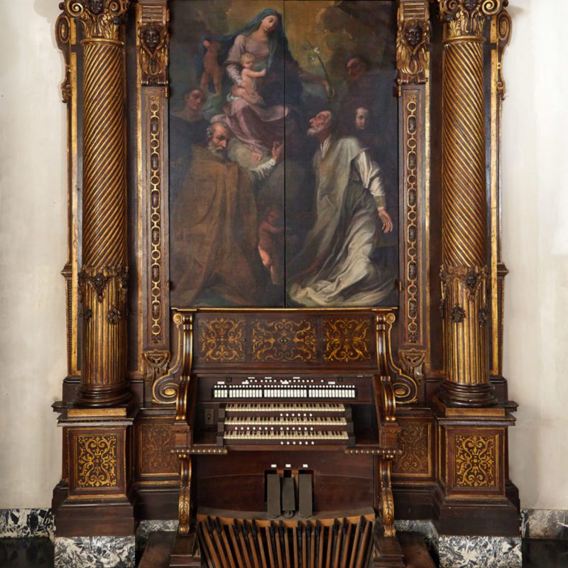 A painting of a woman and a man with a baby and a pipe organ.