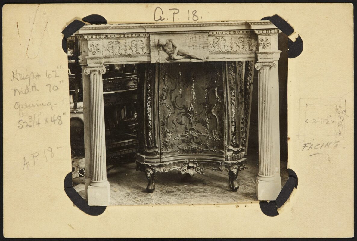 A black and white photo of an ornate fireplace.