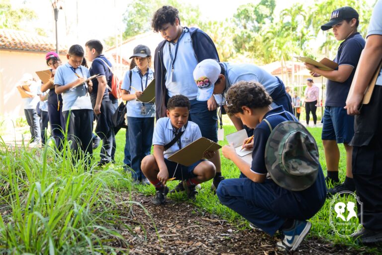 A group of students with clipboards observe and take notes in an outdoor garden setting during a class activity.